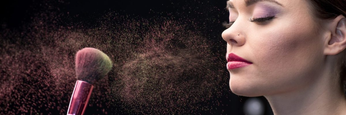 make-up-artist-sprinkling-model-s-face-with-powder-with-help-of-brush-on-black.jpg